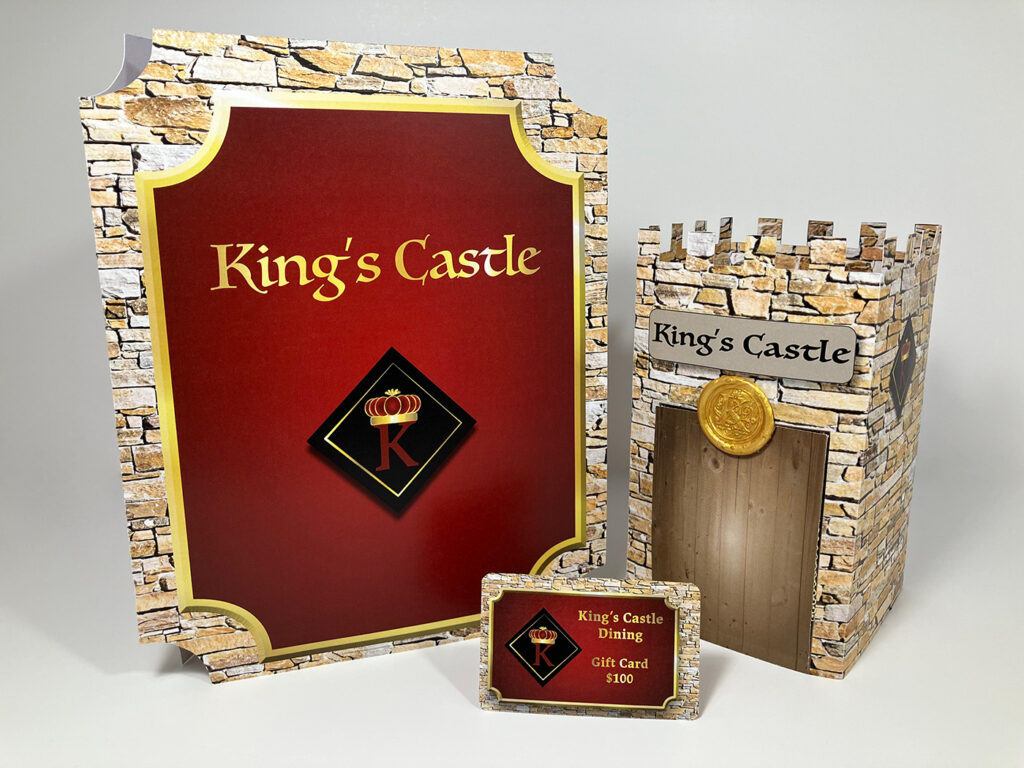 Product photography of King's Castle Restaurant menu, gift card and table topper designs displayed together